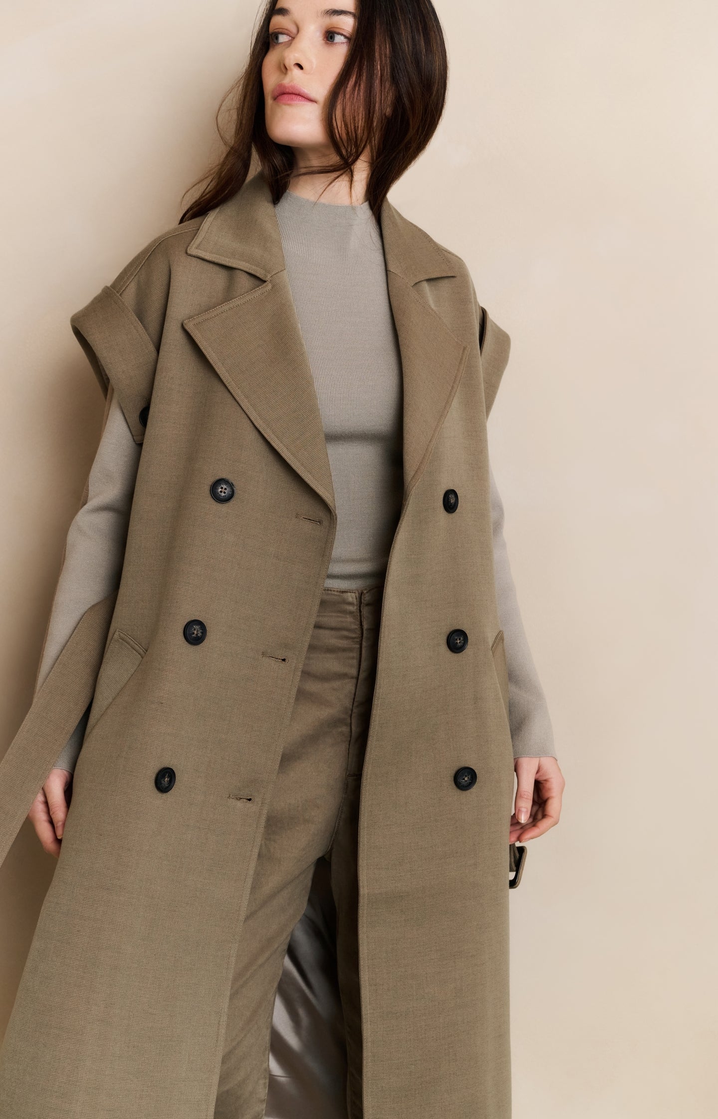 Long sleeveless coat with lapels and waist belt