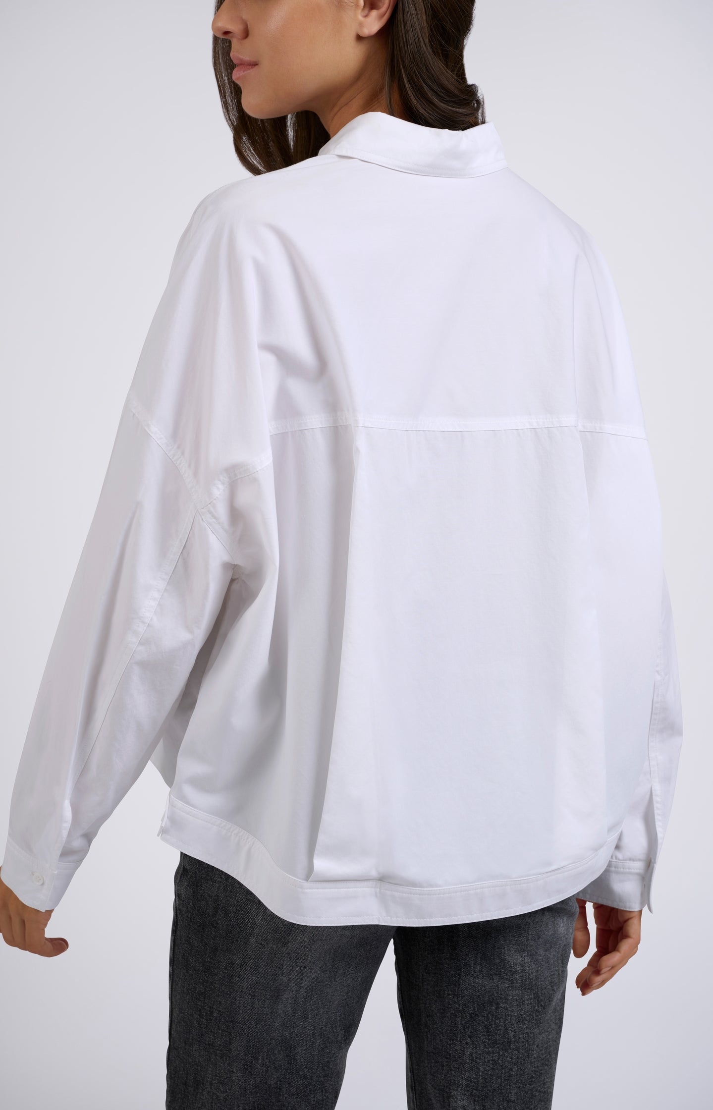 White blouse with batwing sleeves, buttons and chest pockets