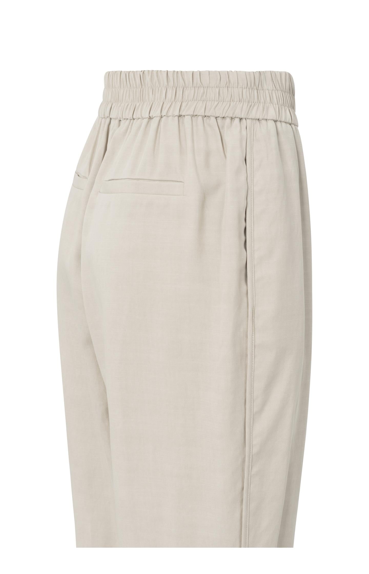 Woven trousers with elastic waistband and curved hem
