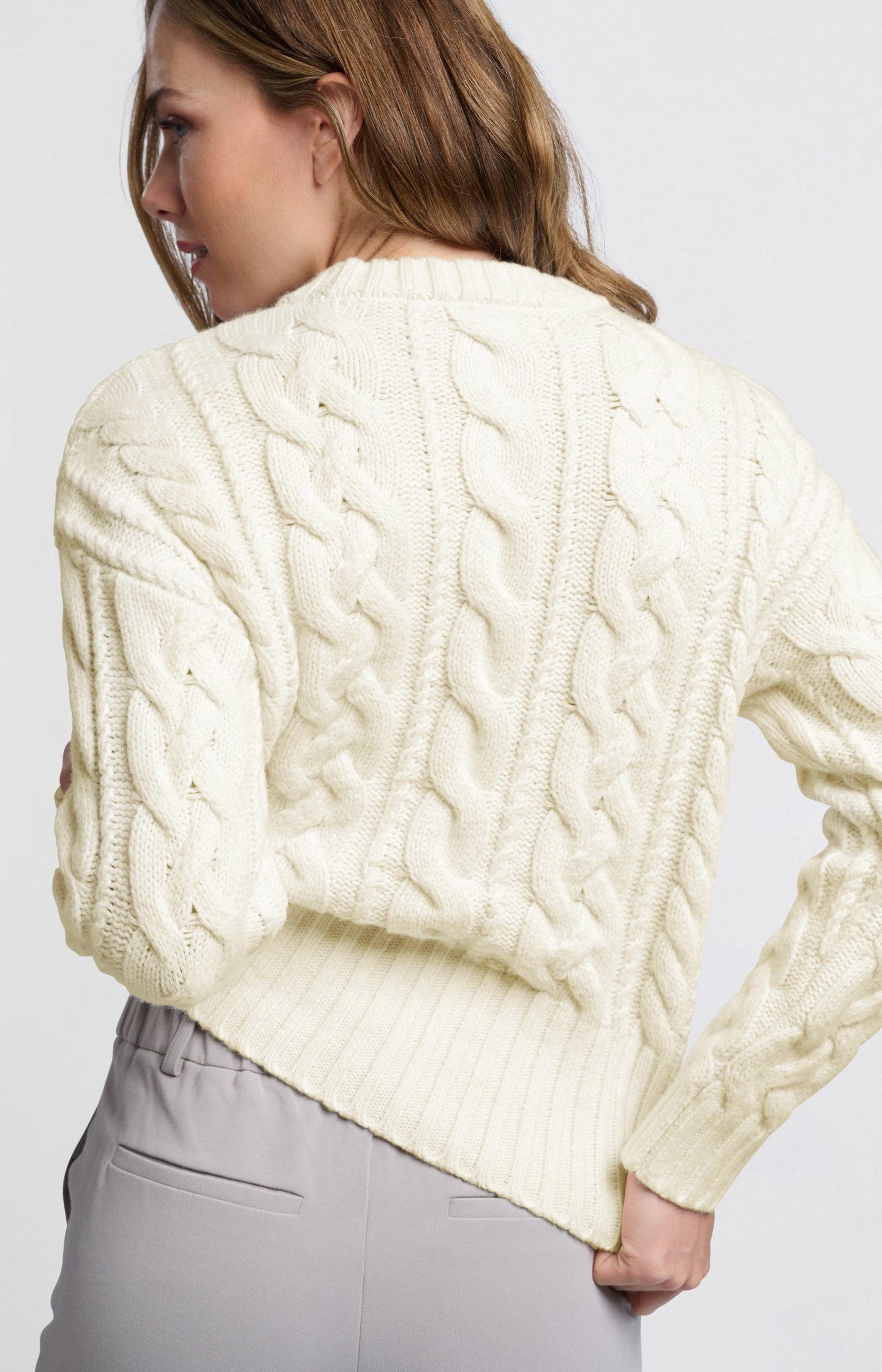 Cream colored cable sweater with round neck and long sleeves