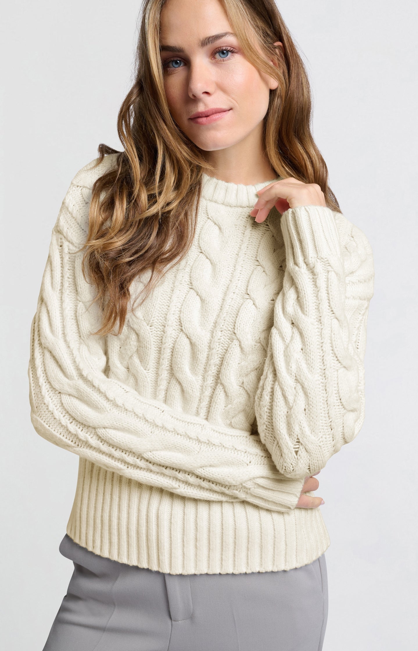 Cream-colored cable sweater with round neck and long sleeves