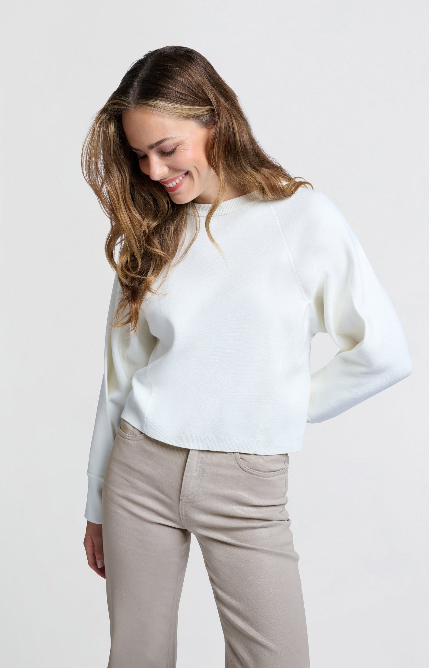 Cream-colored sweater with seam details and wide sleeves