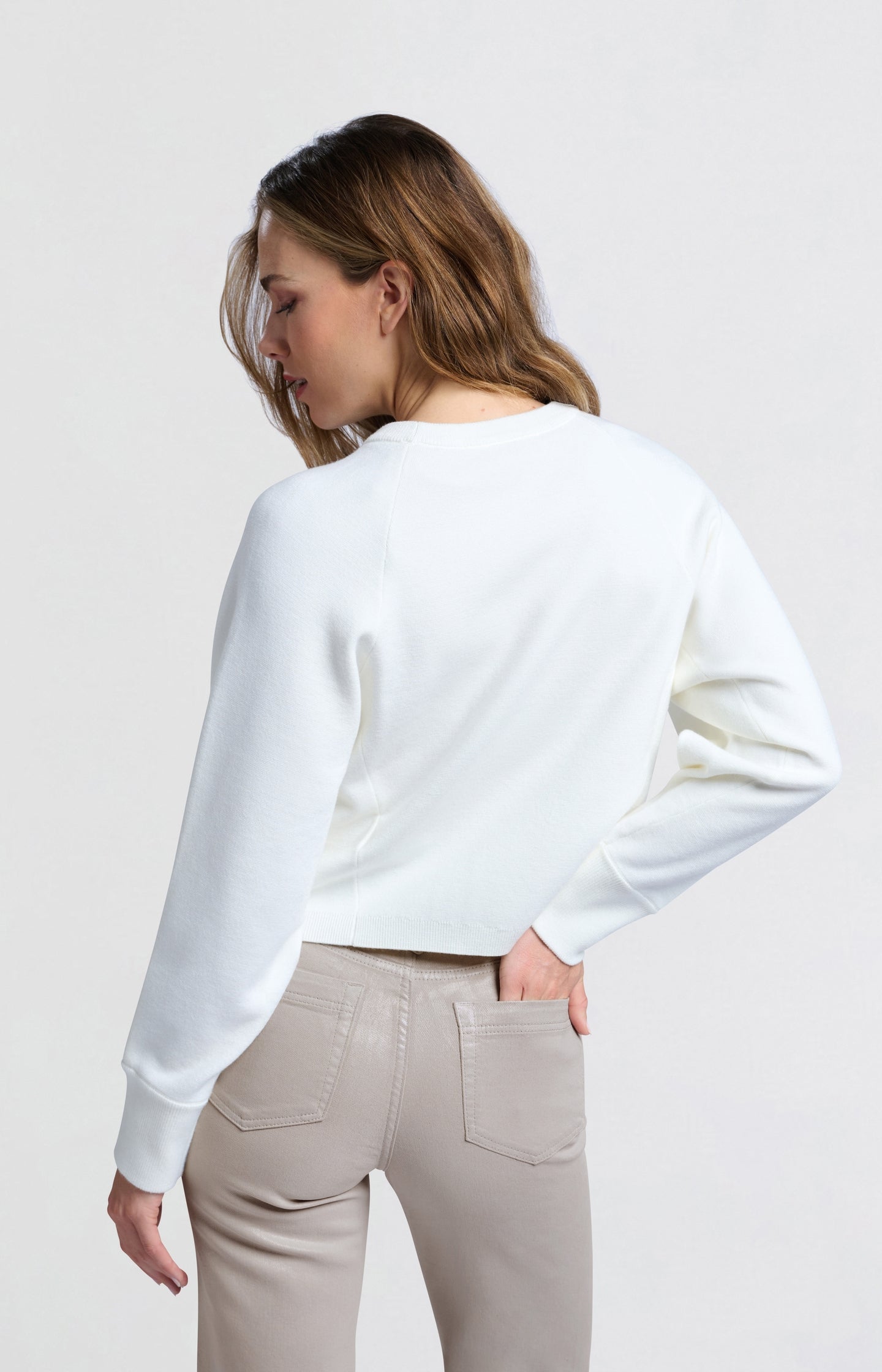 Cream-colored sweater with seam details and wide sleeves