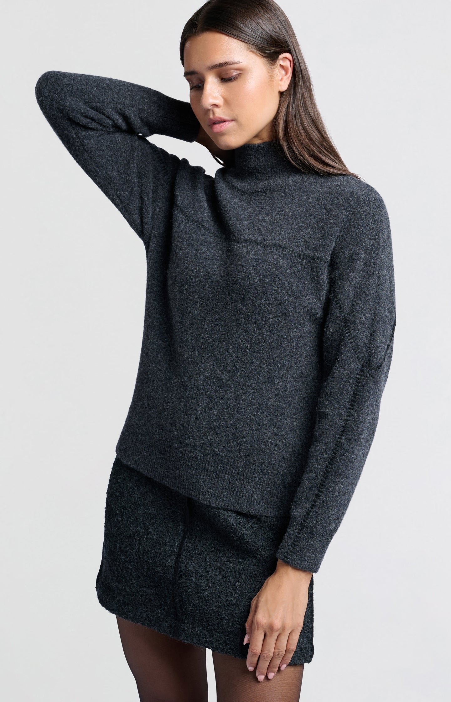 Dark grey sweater with subtle seam detail and high collar