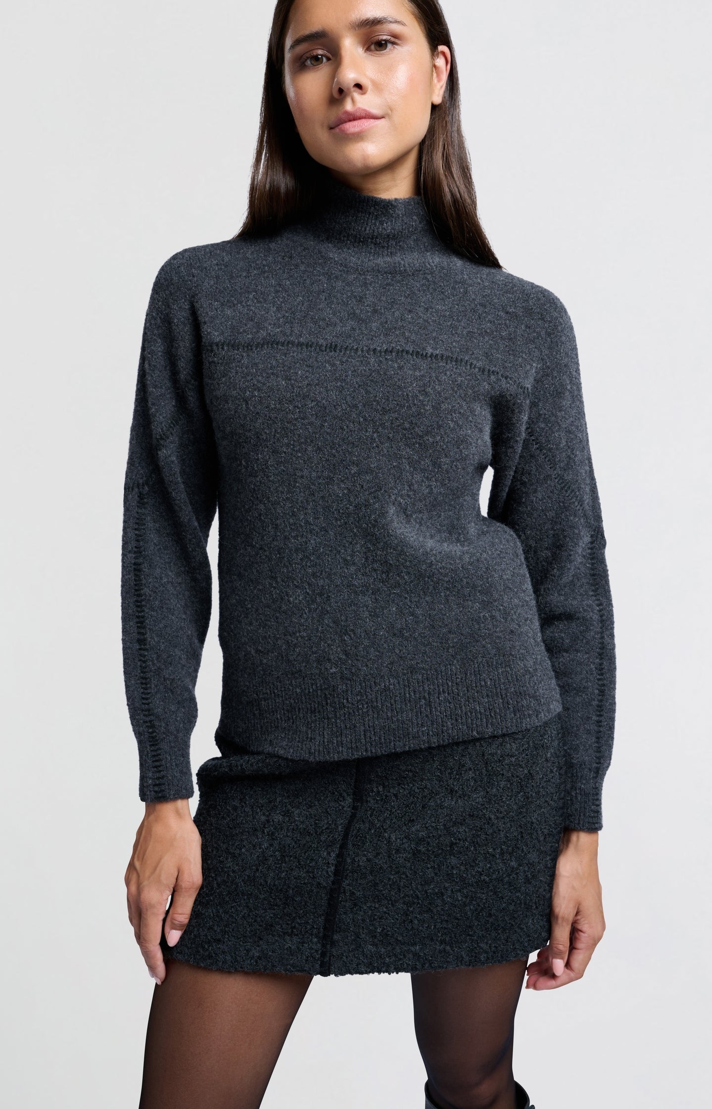 Dark grey sweater with subtle seam detail and high collar