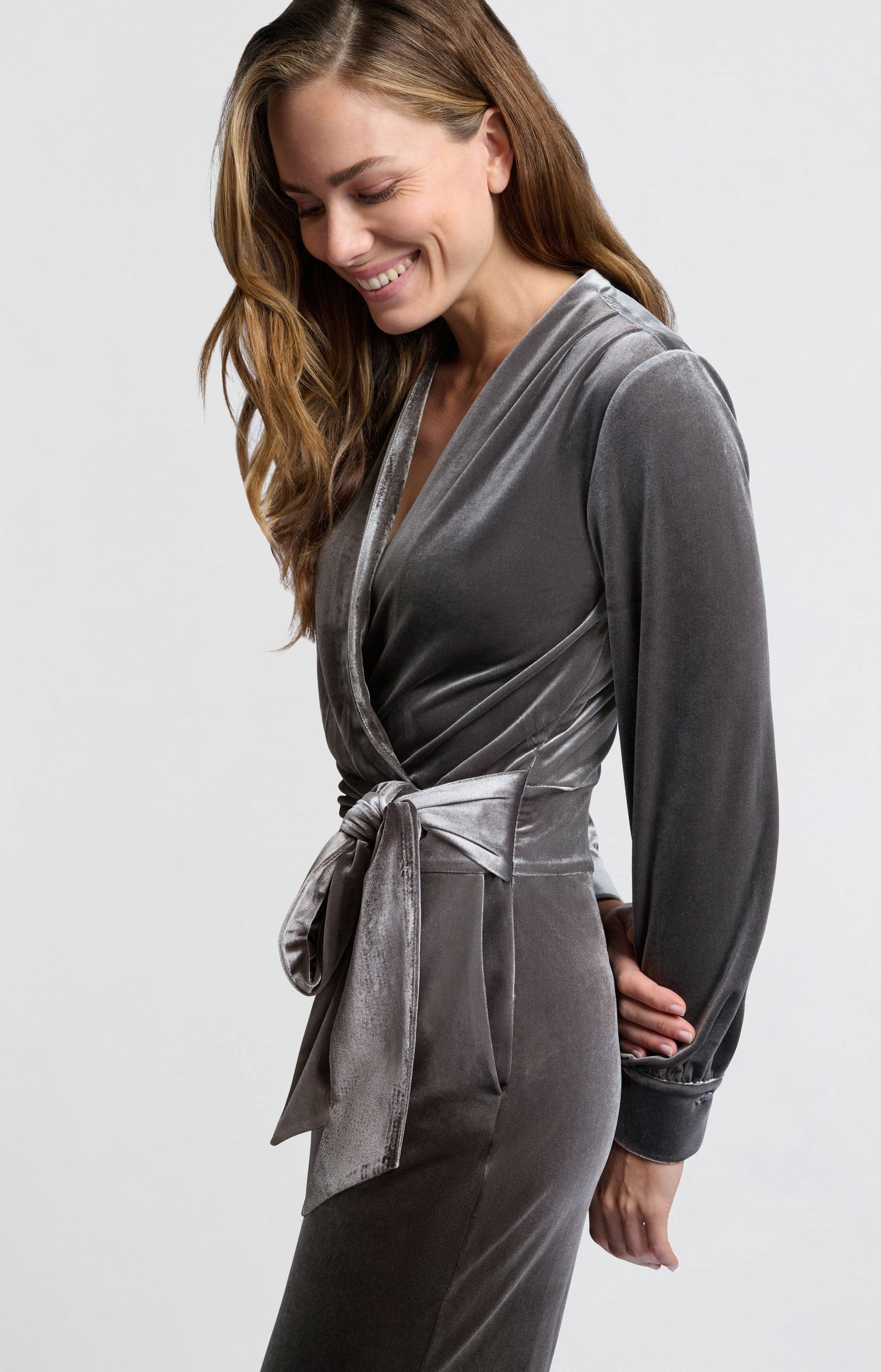 Grey velvet jumpsuit with long sleeves and tie belt