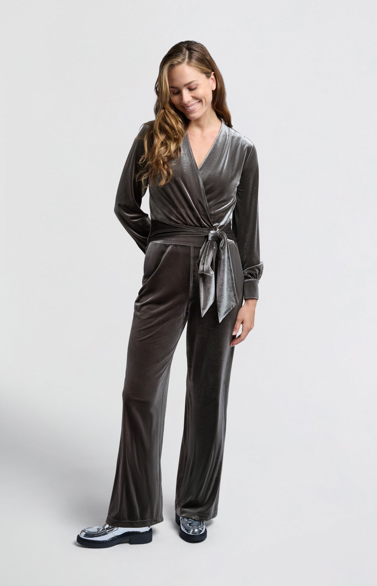 Grey velvet jumpsuit with long sleeves and tie belt