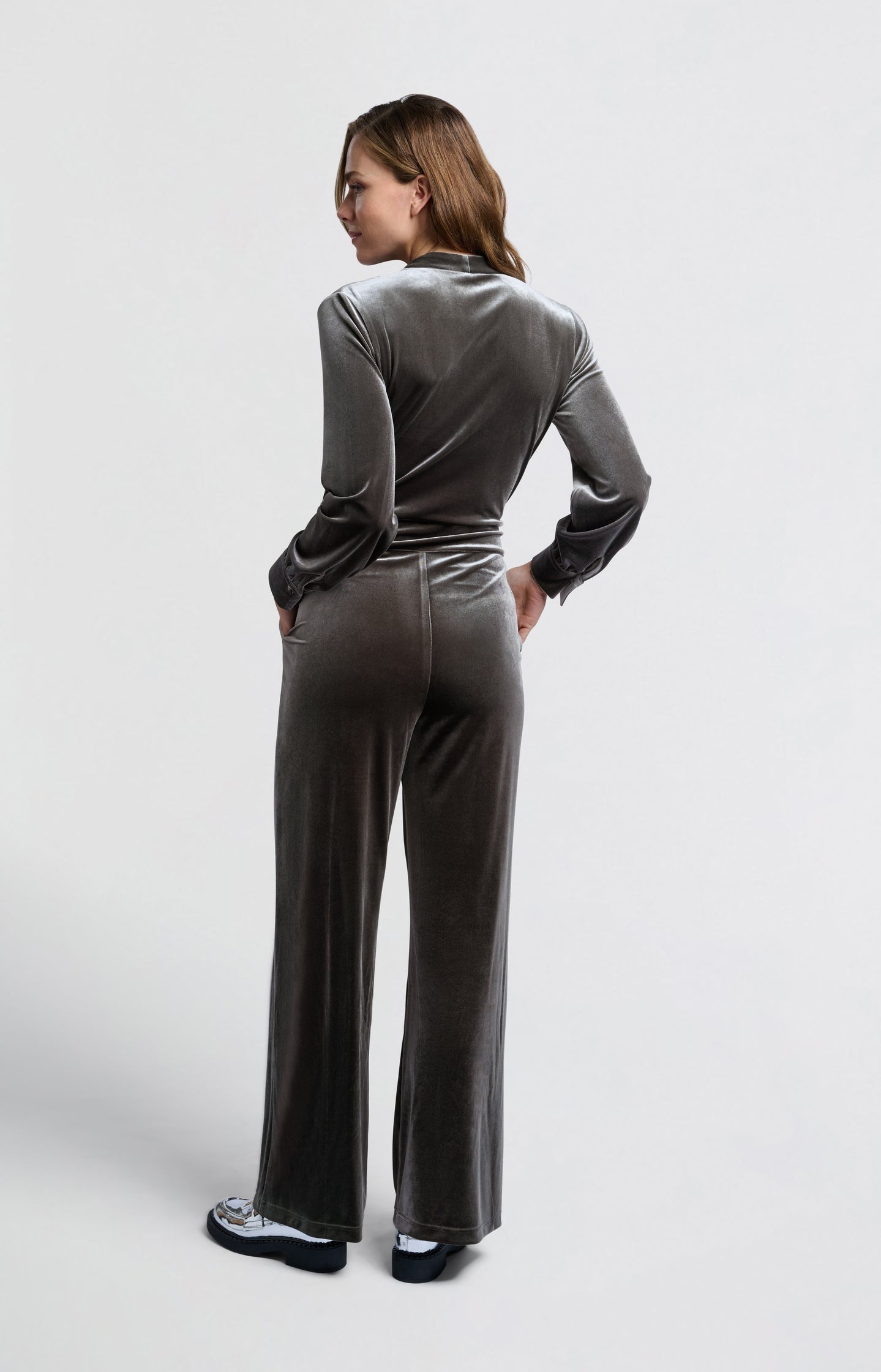 Grey velvet jumpsuit with long sleeves and tie belt