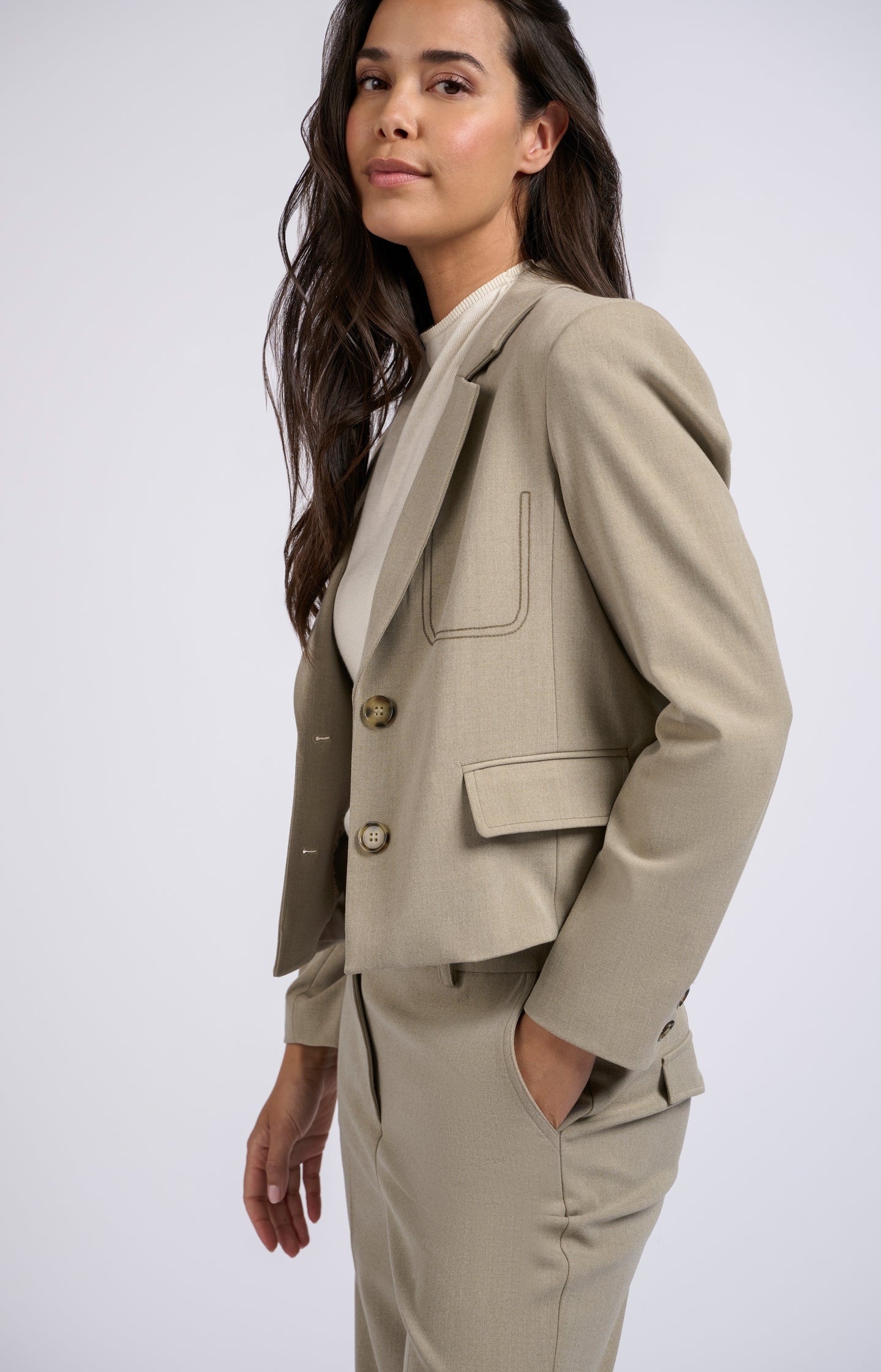 Short beige blazer with buttons, long sleeves and pockets