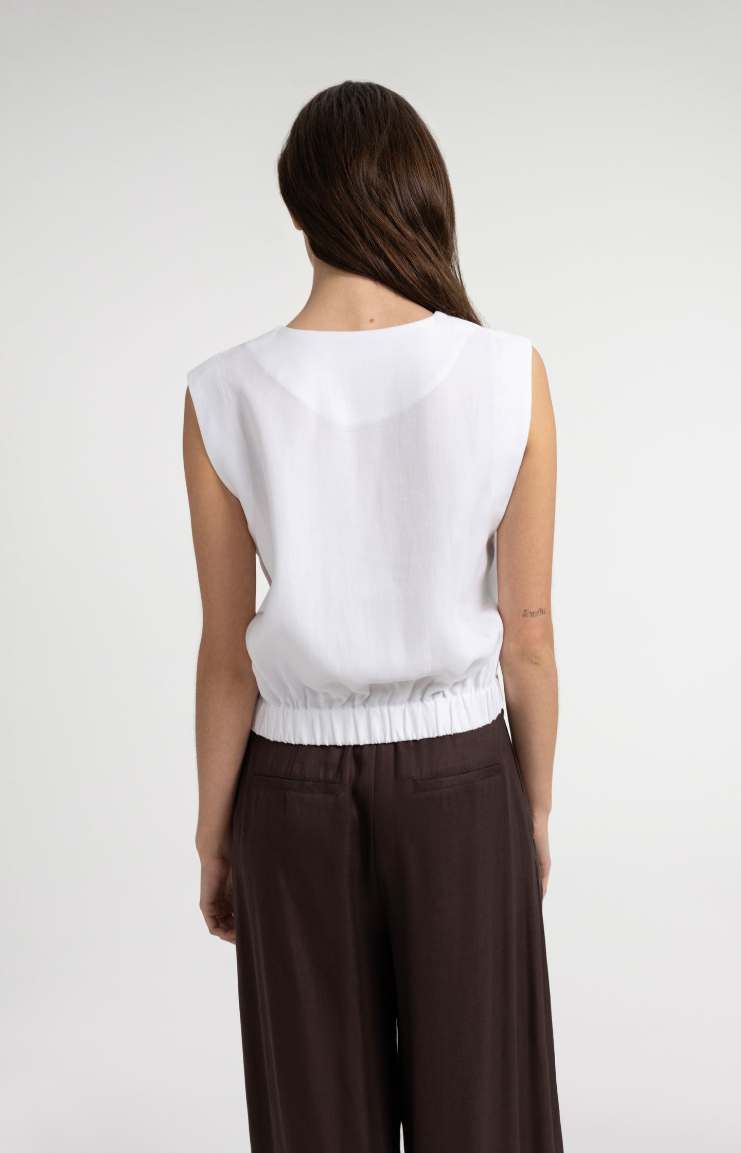Sleeveless blouse with pleat details and elastic hem