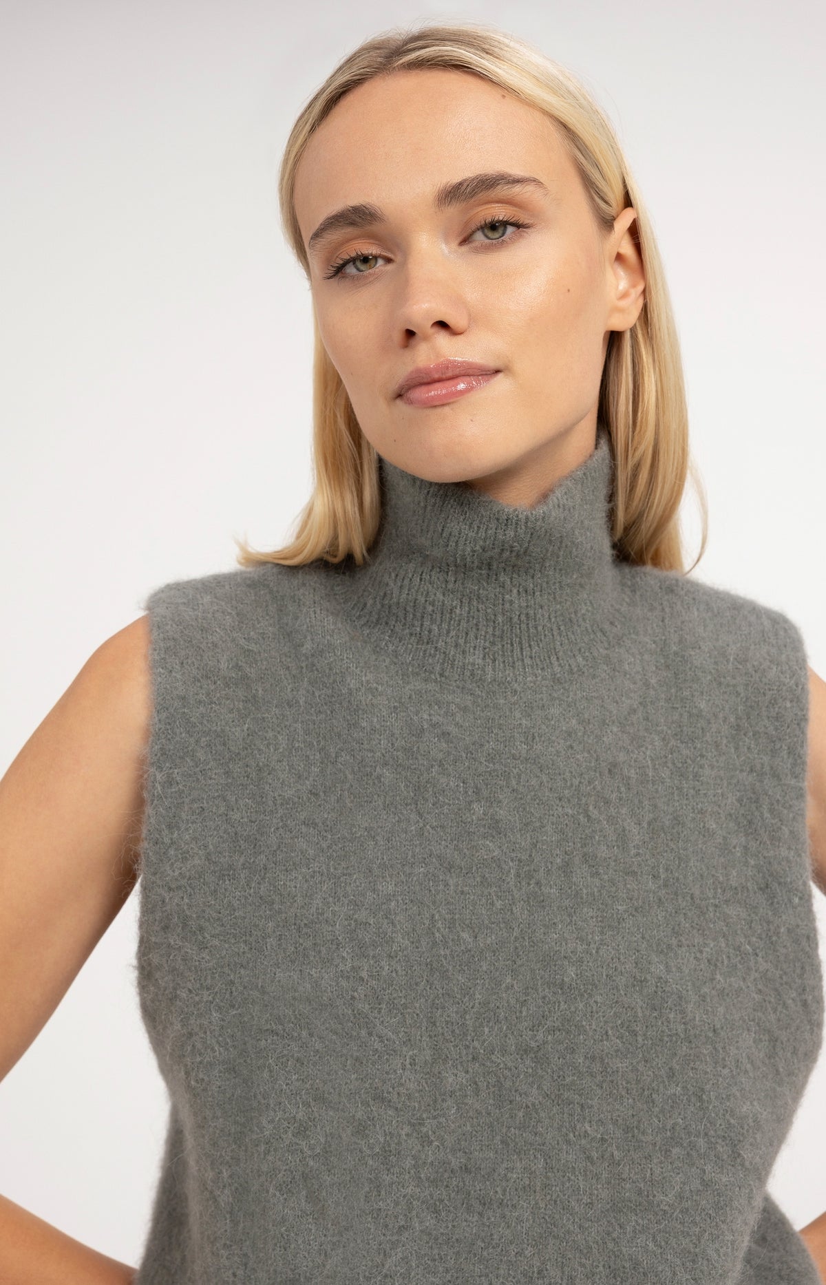 Sleeveless knitted sweater with high neck