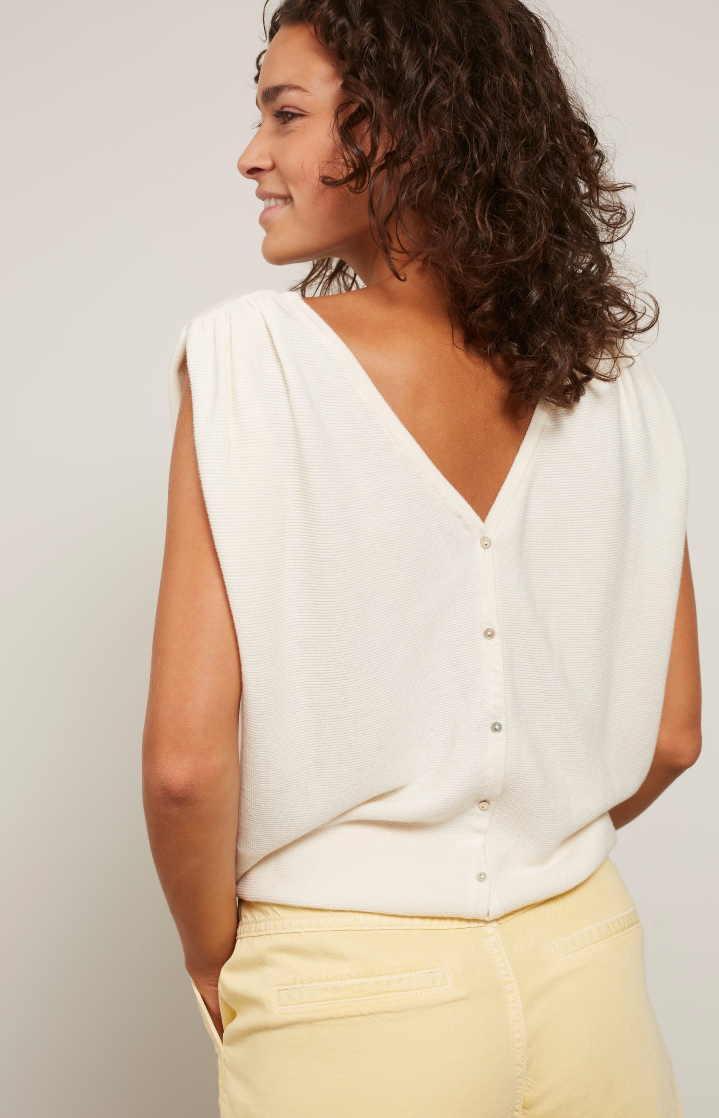 Sleeveless sweater with boat neck and button on back