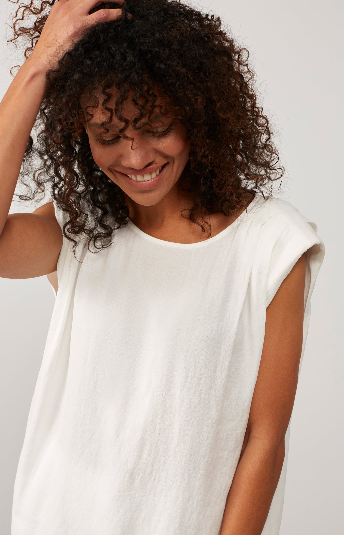 Sleeveless woven top with round neck and shoulder detail