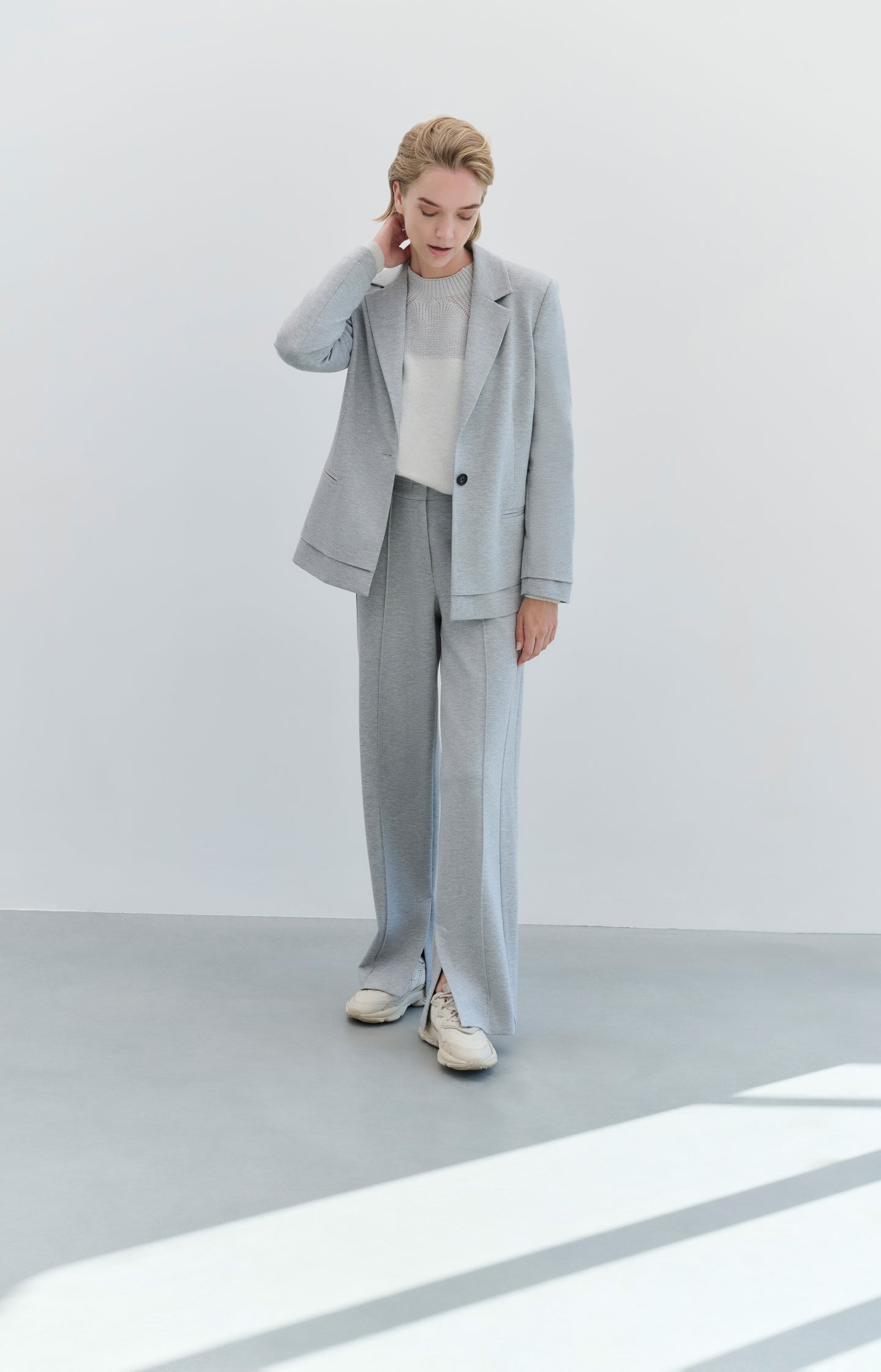 Soft grey trousers with straight legs and crease details