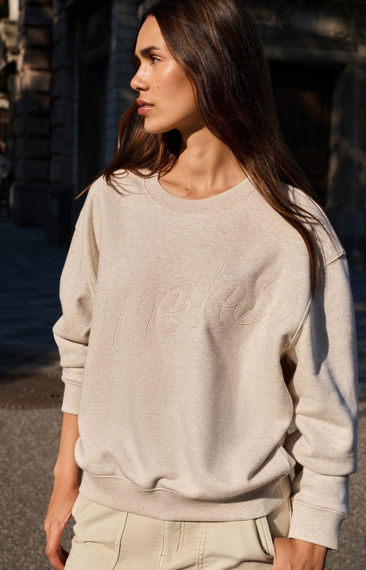 Sweater with stitched-on text and round neckline