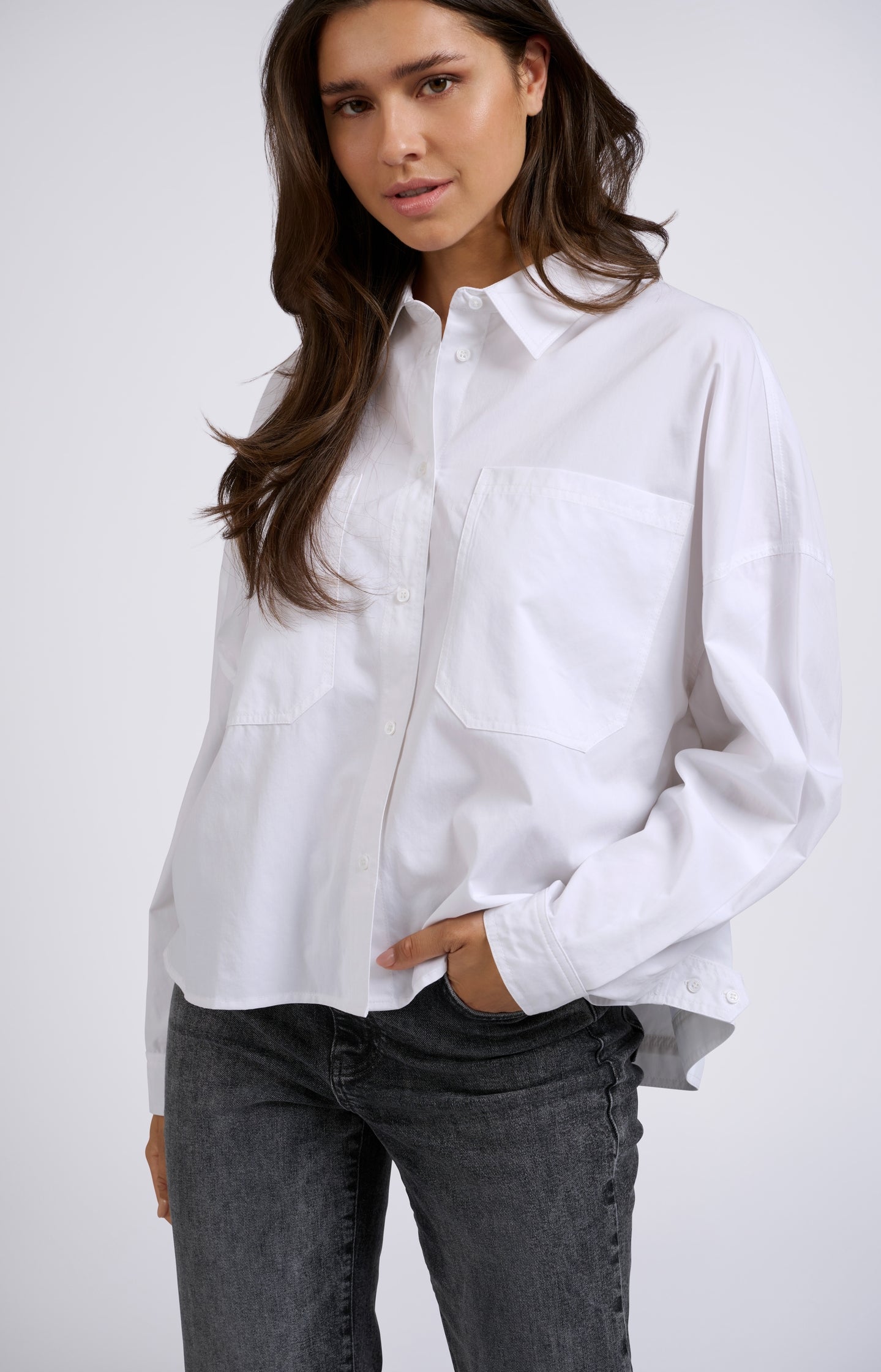 White blouse with batwing sleeves, buttons and chest pockets